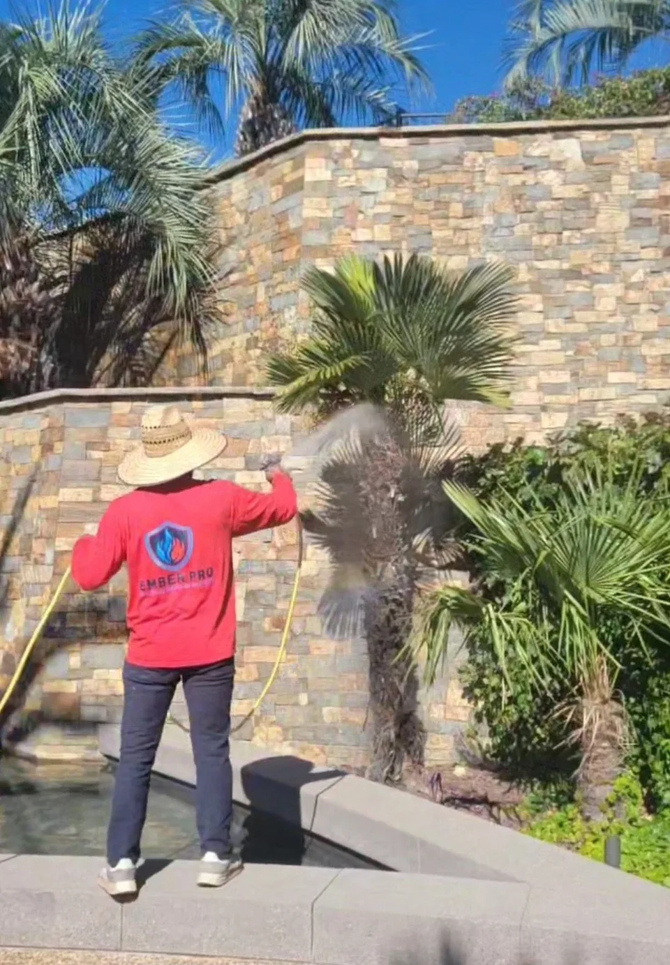 Ember Pro technician applying fire retardant spray to landscaping